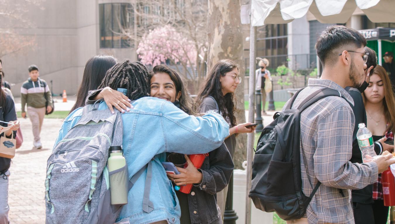 Students hugging in outdoor event 